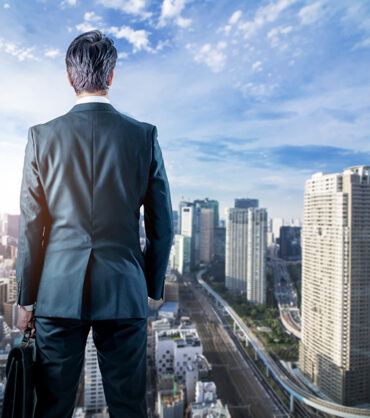 businessman looking down a modern city. business prospect concep