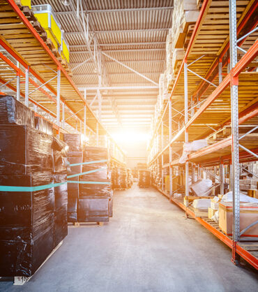 Large hangar warehouse industrial and logistics companies. Warehousing on the floor and called the high shelves. Bright sunlight.