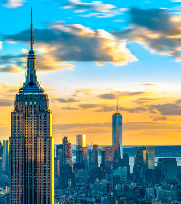 New York landmarks and attractions: Empire State building with One World Trade Center in the distant background. The two buildings represent architecture of two different eras.

One World Trade Center is the tallest building in New York while the Empire State Building is the third tallest building.