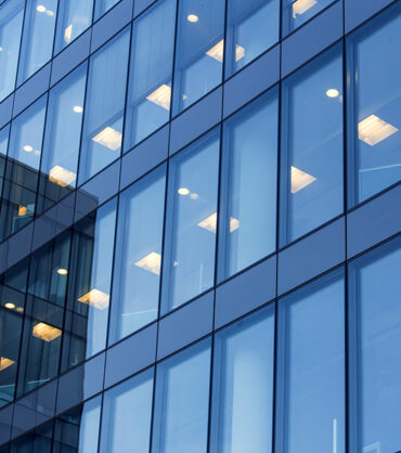 office building windows with inner artificial lamplight in blue color tone