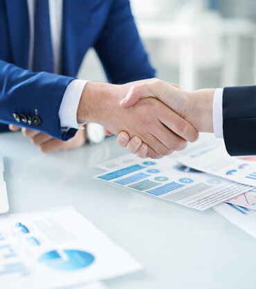 Handshake of business agent and his client after negotiation and signing contract at meeting