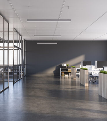 Interior of modern office with grey walls, dark concrete floor, rows of computer tables with flower beds and panoramic windows. 3d rendering