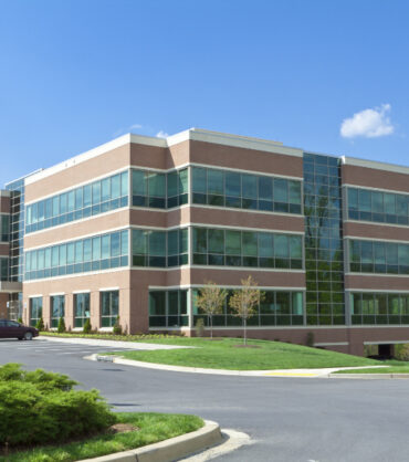 New office building in suburban Maryland, United States.  Parking lot in front of the building with several cars.