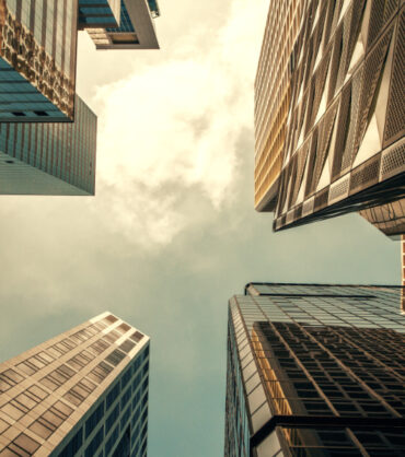 Bottom view of skyscrapers on bright blue sky background. Urban and district concept