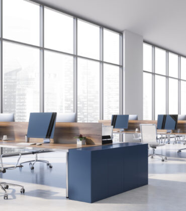 Corner of panoramic open space office with white walls, concrete floor and row of blue computer tables with white metal chairs. 3d rendering