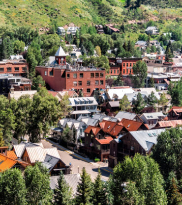 Telluride, Colorado small town with aerial high angle bird's eye view of city cityscape from free gondola to mountain village in summer