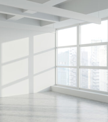 Empty white wall in panoramic industrial style office corner with concrete floor and window with blurry cityscape. Concept of real estate. 3d rendering