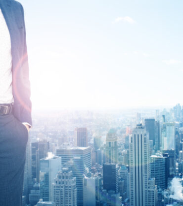 Businessman in suit standing near the window of New York downtown , USA