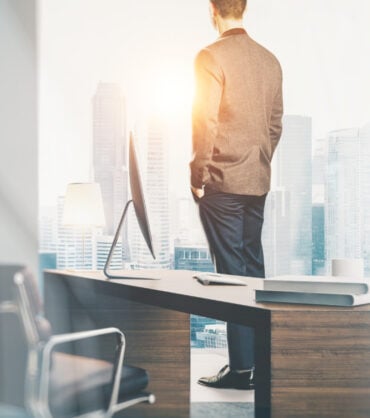 Businessman looking at the city in contemporary office.