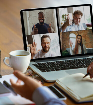 Remote meeting. Man working from home during coronavirus or COVID-19 quarantine, remote office concept. Young businessman, manager in front of monitor during online conference with colleagues and team.
