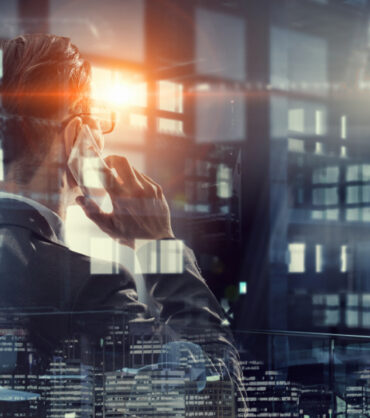Businessman in dark office talking his mobile phone. Mixed media