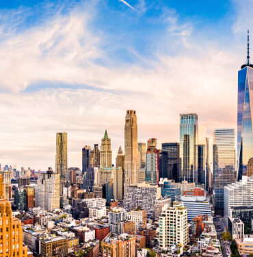 Aerial panorama of Lower Manhattan skyline at sunset viewed from above Greenwich street in Tribeca neighborhood.