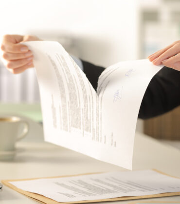 Business woman hands breaking document at the office