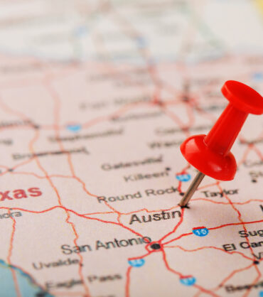 Red clerical needle on a map of USA, Texas and the capital Austin. Closeup Map Texas with Red Tack, US map pin