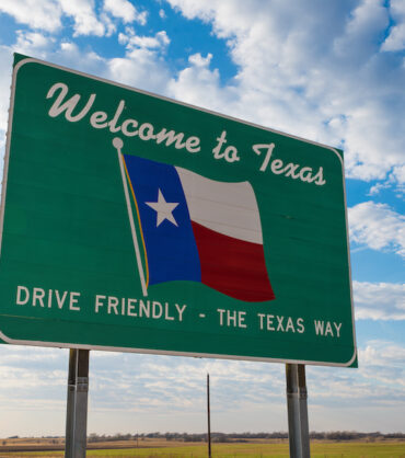 Welcome to Texas road sign in front of cloudy sky