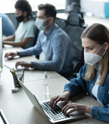Group of business people working in office with new normal lifestyle concept. Man and woman wear protective face mask to prevent covid virus after company reopen again.